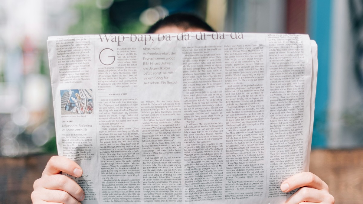 A persong reading a newspaper, used to illustrate the importance of media literacy